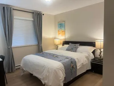 a bedroom with a large bed and a window at Coquitlam center, 2 bedroom suite, walking to skytrain in Port Coquitlam