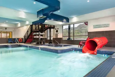 a large swimming pool with a red slide in it at Fairfield Inn & Suites by Marriott Vernon in Vernon