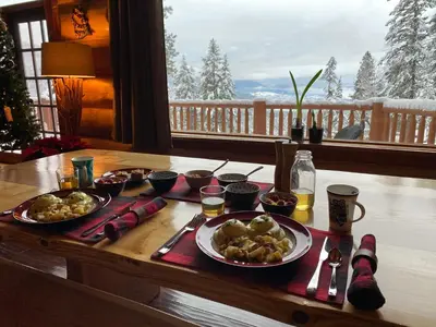 a table with plates of food on it with a view at Spirit Lodge at Silverstar in Vernon