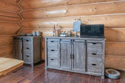 a wooden room with a counter with drawers and a microwave at Spirit Lodge at Silverstar in Vernon