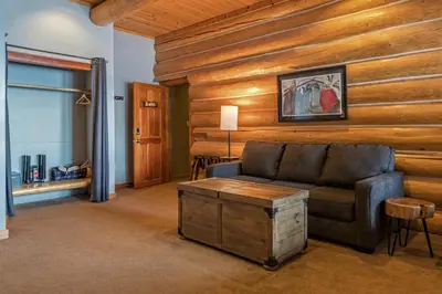 a living room with a couch and a wooden wall at Spirit Lodge at Silverstar in Vernon