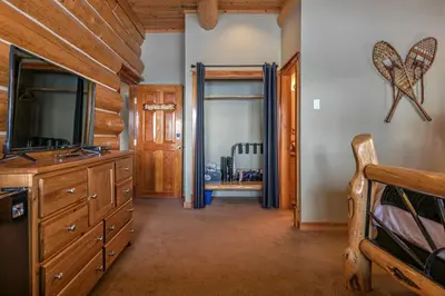 a bedroom with a dresser and a sliding glass door at Spirit Lodge at Silverstar in Vernon