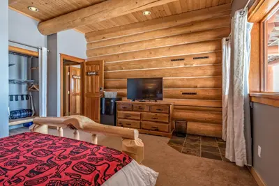 a bedroom with a wooden accent wall and a tv at Spirit Lodge at Silverstar in Vernon