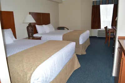 a hotel room with two beds and a table and chairs at Hinton Lodge in Hinton
