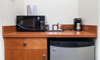 a microwave sitting on top of a wooden counter next to a refrigerator at Hinton Lodge in Hinton