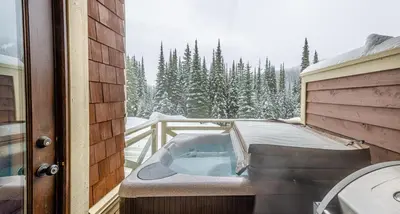 a hot tub on the balcony of a house at Stones Throw #26 By Bear Country in Sun Peaks