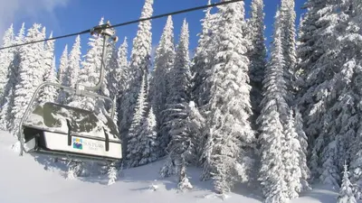 a ski lift with snow covered trees at Stones Throw #26 By Bear Country in Sun Peaks