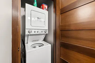 a laundry room with a washer and dryer next to a door at Stones Throw #26 By Bear Country in Sun Peaks