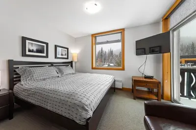 a bedroom with a bed and a window at Kookaburra Lodge #203 By Bear Country in Sun Peaks