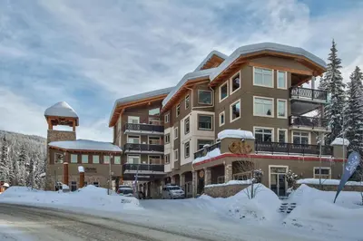 a large apartment building with snow on the ground at Kookaburra Lodge #203 By Bear Country in Sun Peaks