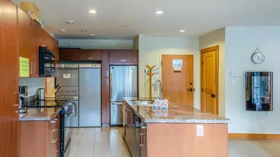 a large kitchen with wooden cabinets and a counter top at Kookaburra Lodge #303 By Bear Country in Sun Peaks