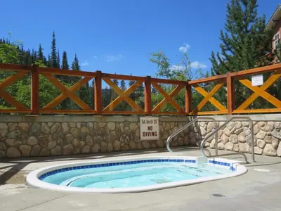 a hot tub with a fence and a no swimming sign at Fireside Lodge #413 By Bear Country in Sun Peaks
