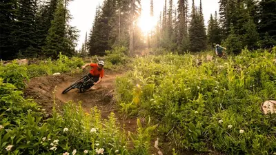 a man riding a dirt bike on a dirt trail at Fireside Lodge #413 By Bear Country in Sun Peaks
