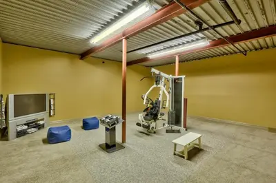 a room with a gym with a television and a machine at Soleil Chalet By Bear Country in Sun Peaks