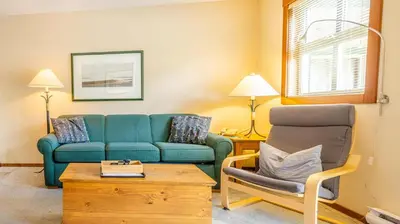 a living room with a blue couch and a chair at Holiday Home in Sun Peaks