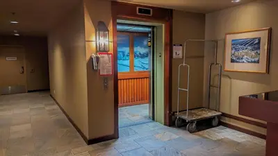 a hospital hallway with a door and a luggage cart at Fireside Lodge #315 By Bear Country in Sun Peaks