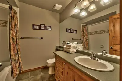 a bathroom with a sink and a toilet and a mirror at Timberline Village #14 By Bear Country in Sun Peaks