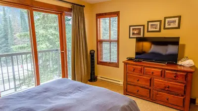 a bedroom with a bed and a television on a dresser at Woodhaven #32 By Bear Country in Sun Peaks