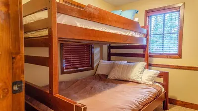 a bedroom with bunk beds with a couch in a room at Woodhaven #32 By Bear Country in Sun Peaks