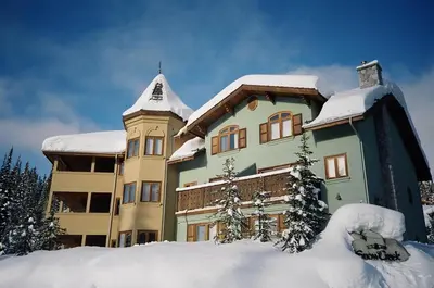 a large building with snow on the ground in front of it at Snow Creek Village #48 By Bear Country in Sun Peaks