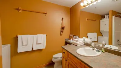 a bathroom with a sink and a toilet and a mirror at Snow Creek Village #48 By Bear Country in Sun Peaks