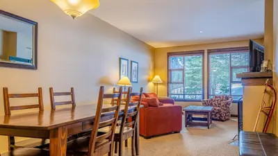 a living room with a dining room table and a couch at Stones Throw #11 By Bear Country in Sun Peaks