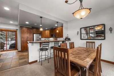 a kitchen and dining room with a wooden table and chairs at Trappers Landing #11 By Bear Country in Sun Peaks