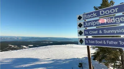 a sign at the top of a snow covered mountain at Trappers Landing #06 By Bear Country in Sun Peaks