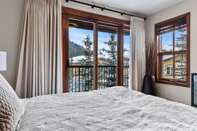 a bedroom with a bed and a large window at Trappers Landing #05 By Bear Country in Sun Peaks