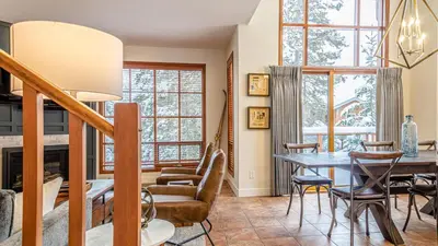 a living room with a table and chairs at Trails Edge #25 By Bear Country in Sun Peaks