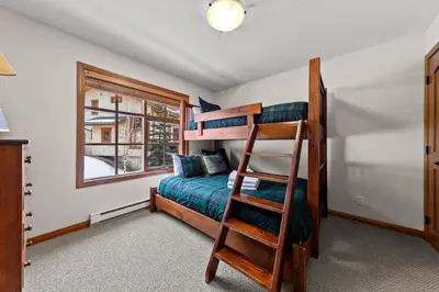 a bedroom with a bunk bed and a ladder at Trails Edge #17 By Bear Country in Sun Peaks