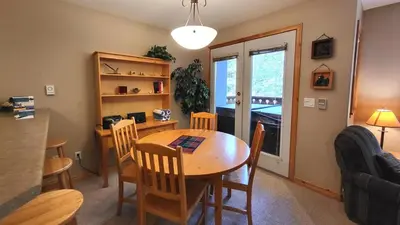 a kitchen and dining room with a table and chairs at Crystal Forest #11 By Bear Country in Sun Peaks