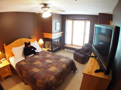 a bedroom with a teddy bear sitting on a bed at Crystal Forest #07 By Bear Country in Sun Peaks