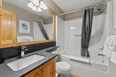 a bathroom with a sink and a tub and a toilet at Crystal Forest #22 By Bear Country in Sun Peaks