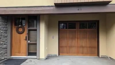 a pair of wooden doors on a house at Village Walk #21 By Bear Country in Sun Peaks