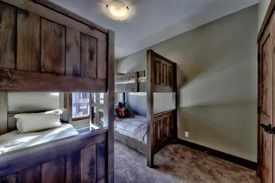 a bedroom with two bunk beds and a bunk bed in it at Village Walk #21 By Bear Country in Sun Peaks