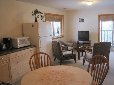 a kitchen with a refrigerator and a table and chairs at Wild Nature B&B in Kelowna