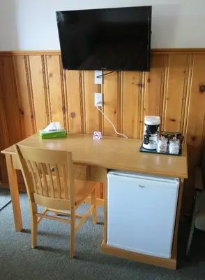 a wooden table with a television on top of it at Gateway Motel in Radium Hot Springs