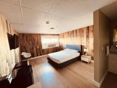 a bedroom with a bed and a television in it at Camrose Le Chateau Hotel in Camrose