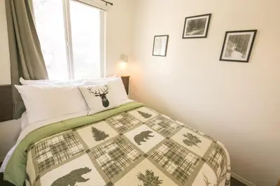a bedroom with a bed with a quilt on it at Mountain Springs Motel in Radium Hot Springs