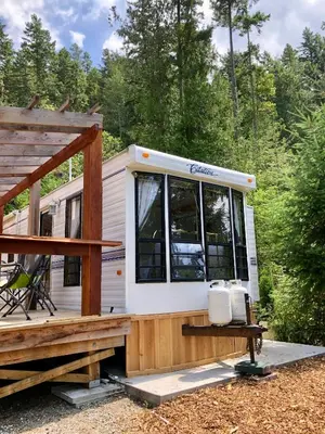 a tiny house with a porch and a deck at Garden Bay Hideaway - Glamping & RV in Garden Bay