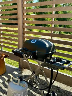 a grill sitting on a stand next to a fence at Garden Bay Hideaway - Glamping & RV in Garden Bay