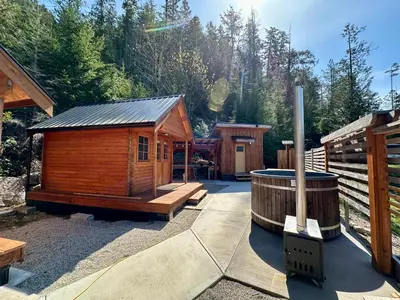 a wooden cabin with a hot tub in a yard at Garden Bay Hideaway - Glamping & RV in Garden Bay