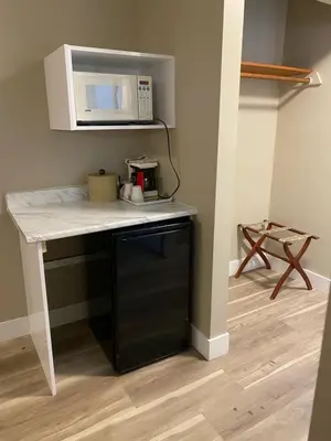 a kitchen with a counter top with a microwave at Imperial Motel in One Hundred Mile House
