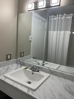 a bathroom with a sink and a mirror at Imperial Motel in One Hundred Mile House