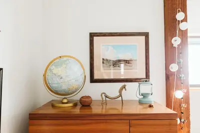 a mirror on top of a wooden dresser at Pacific Soul Eco-Luxe Vacation Home in Ucluelet