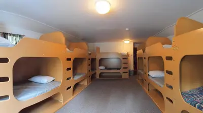 a room with bunk beds and a tv at HI Castle Mountain - Hostel in Castle Junction