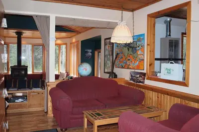 a living room with a red couch and a table at HI Castle Mountain - Hostel in Castle Junction