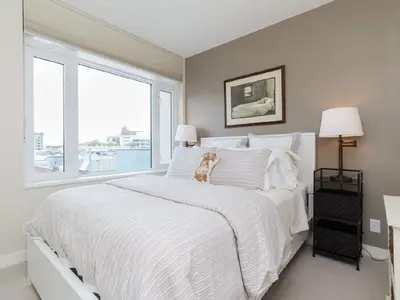 a white bed with a dog sitting on top of it at City Centre in Victoria