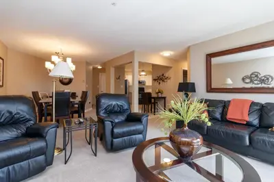 a living room with a couch and chairs and a table at Deluxe 2 Bed 2 Bath With Harbour And Empress Hotel Views in Victoria